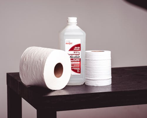 Free A Pair of Tissue Rolls and a Bottle of Isopropyl Alcohol on a Wooden bench Stock Photo