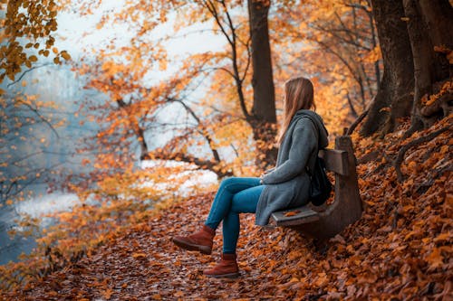 Photo Of Woman Sitting On Wooden Bench