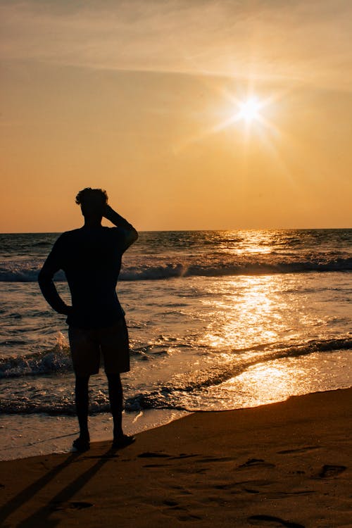 Free Photo Of Person Standing Beside Beach  Stock Photo