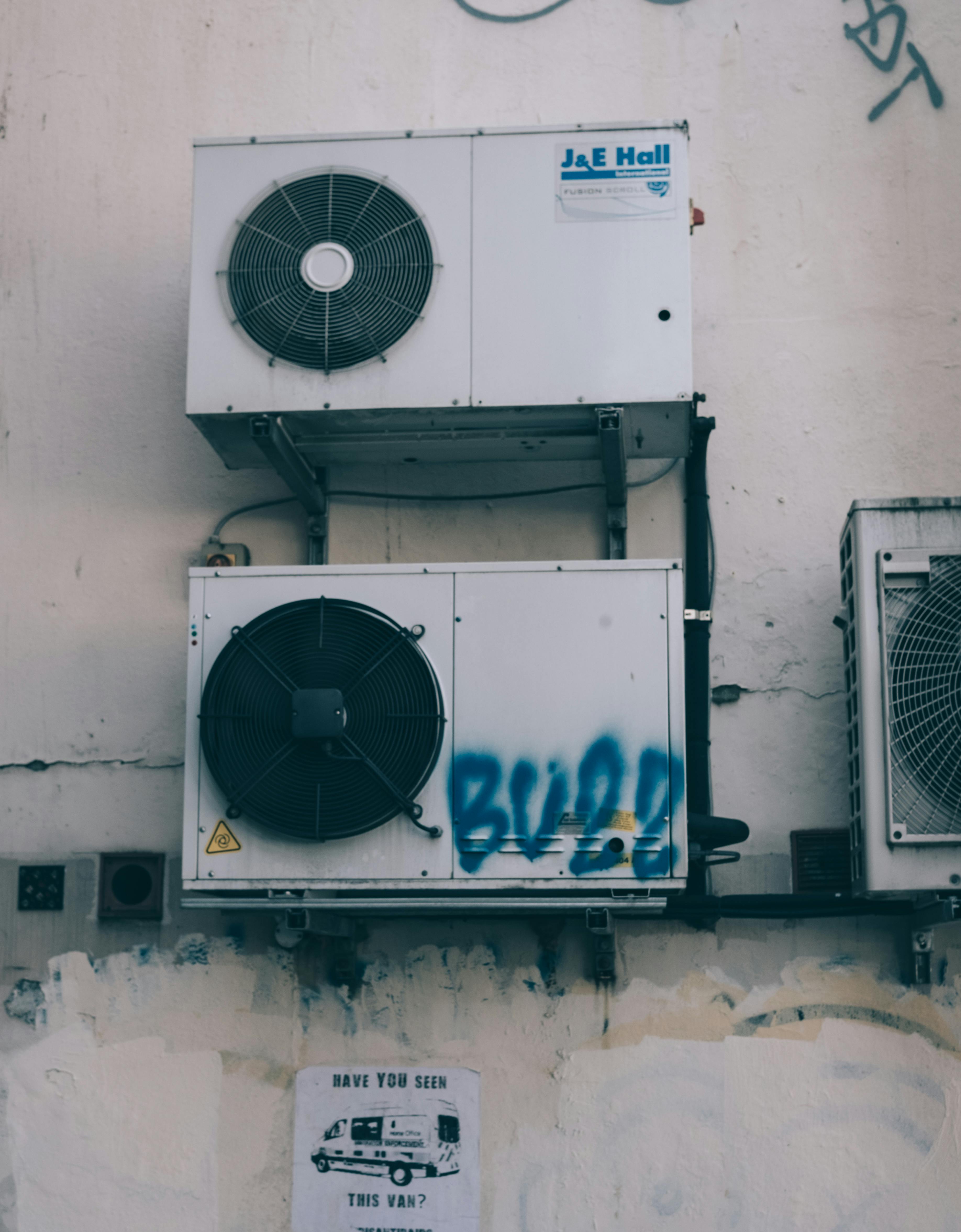dirty air conditioners on grungy building wall