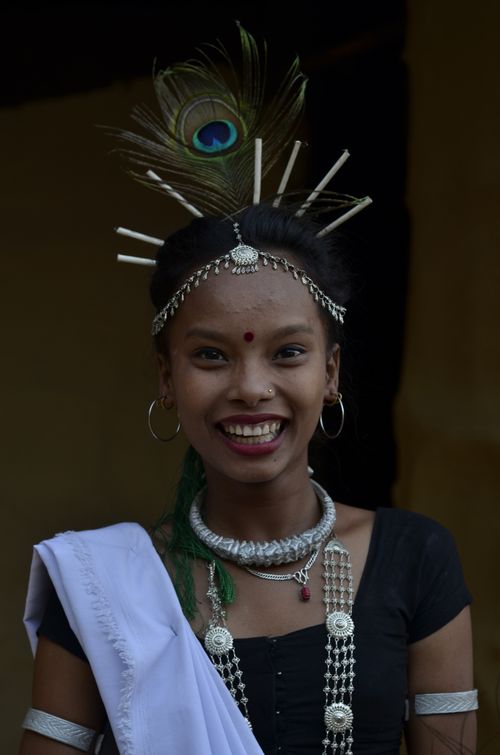 Free Portrait of a cheerful woman in Nepalese traditional clothing with a peacock feather adornment. Stock Photo