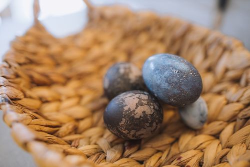 Free Close-up of uniquely dyed Easter eggs displayed in a wicker basket, capturing a rustic aesthetic. Stock Photo