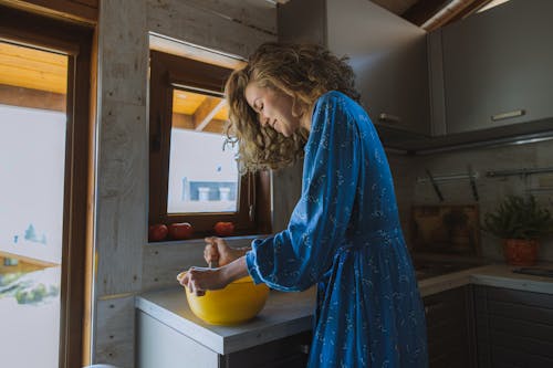 Free Woman In Blue Dress Holding a Yellow Bowl Stock Photo