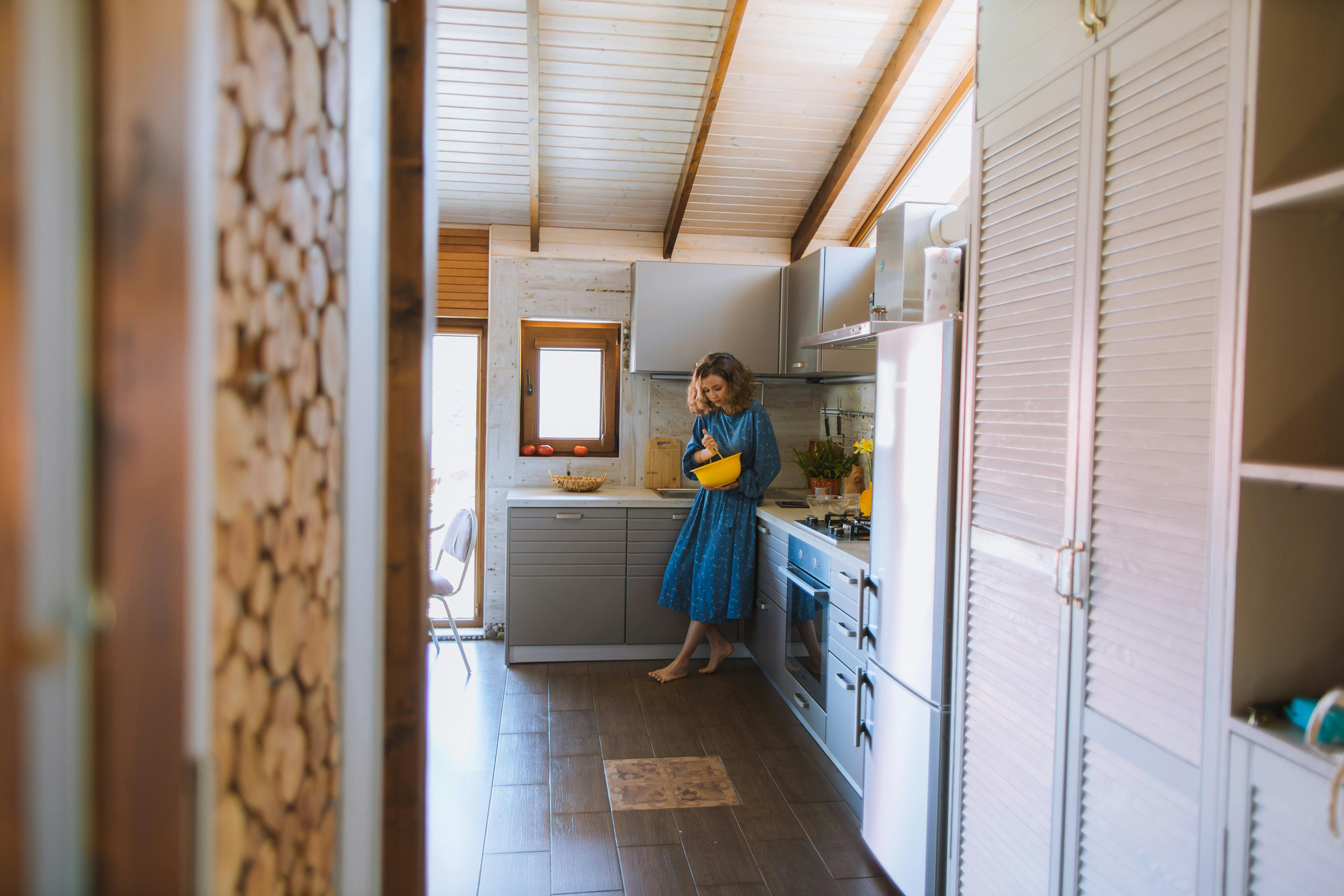 woman in blue dress holding a yellow bowl