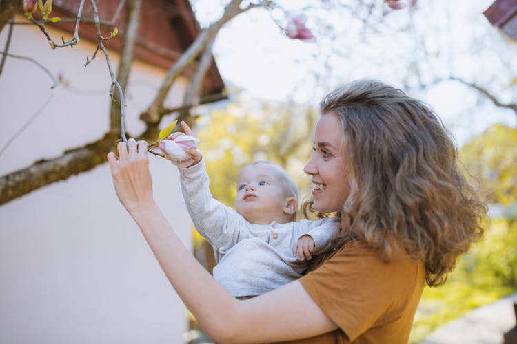 Woman And Baby Grabbing A Flower