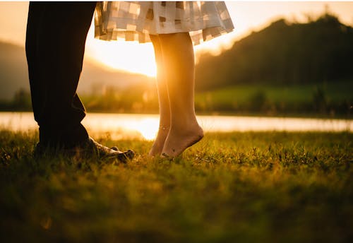 Мужчина и женщина, стоящие на зеленой траве