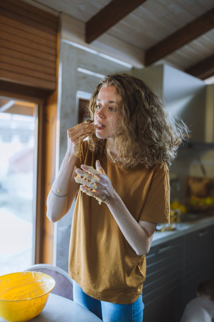 Woman Tasting Dough From Her Hands