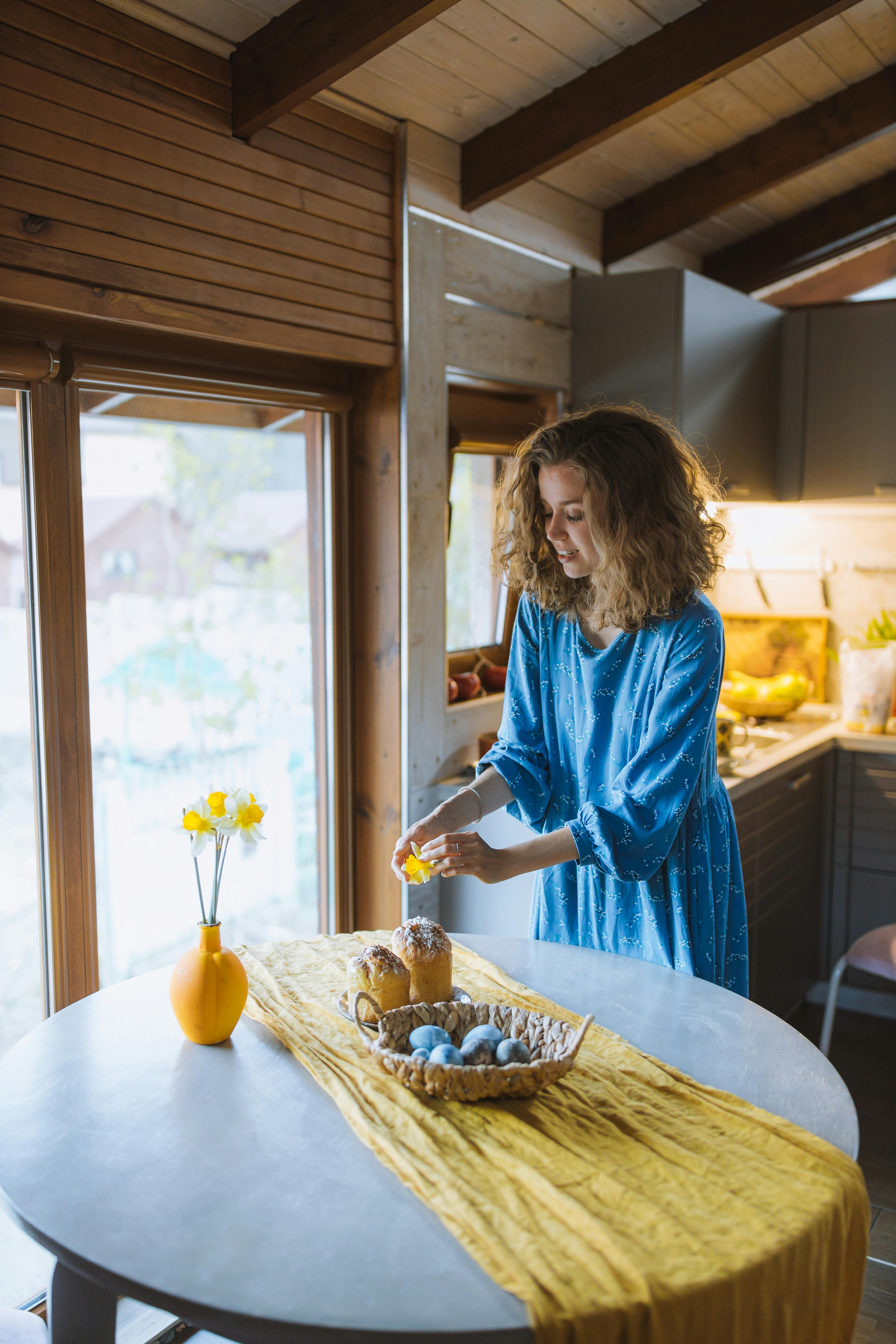 woman decorating a cake with a flower