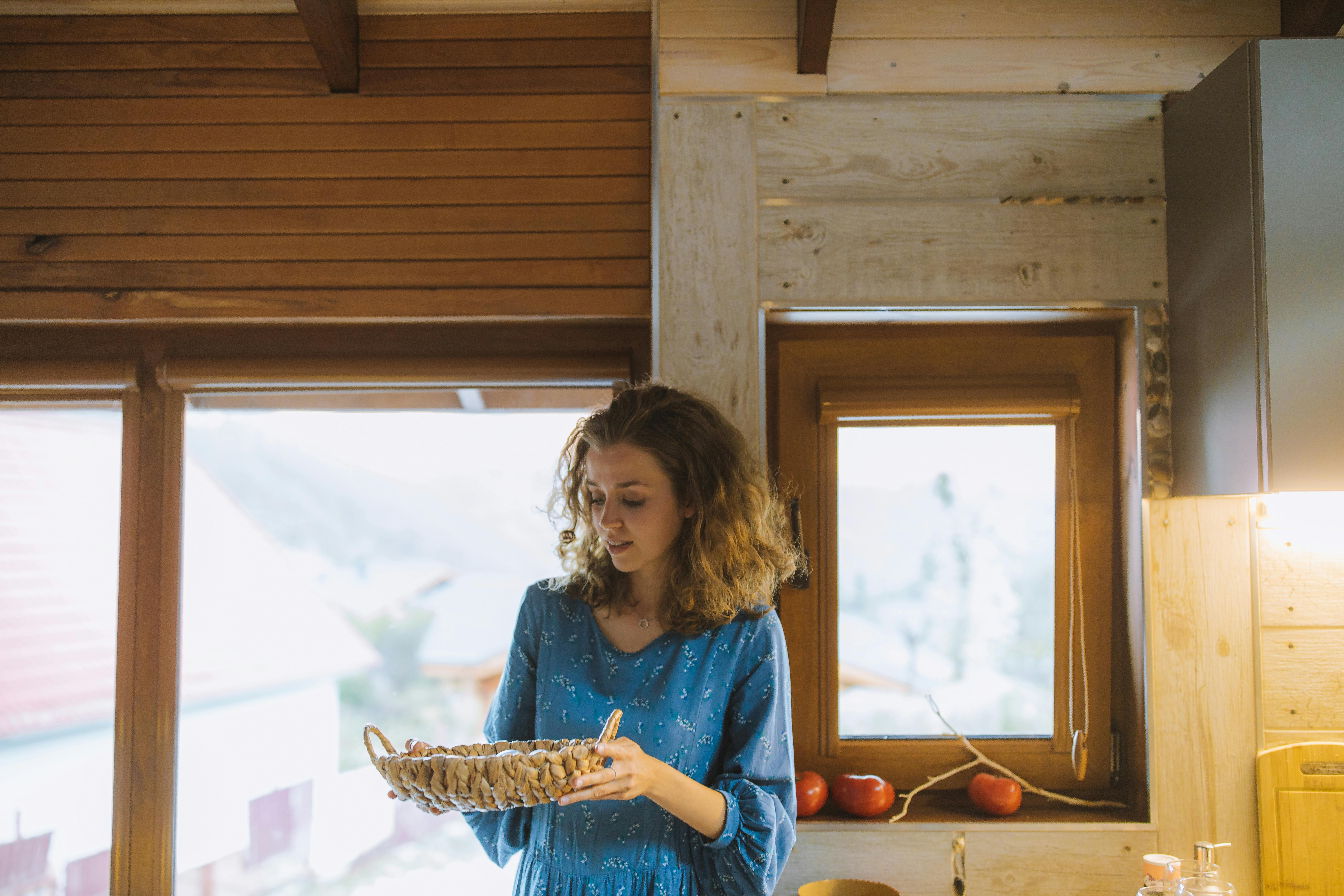 woman in blue long sleeve dress holding a bowl