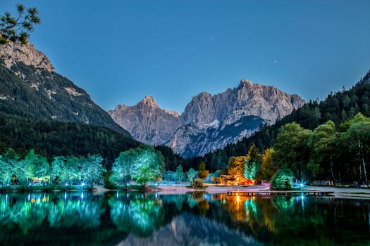 Scenic view of the Julian Alps with vibrant reflections on the lake at night in Slovenia.