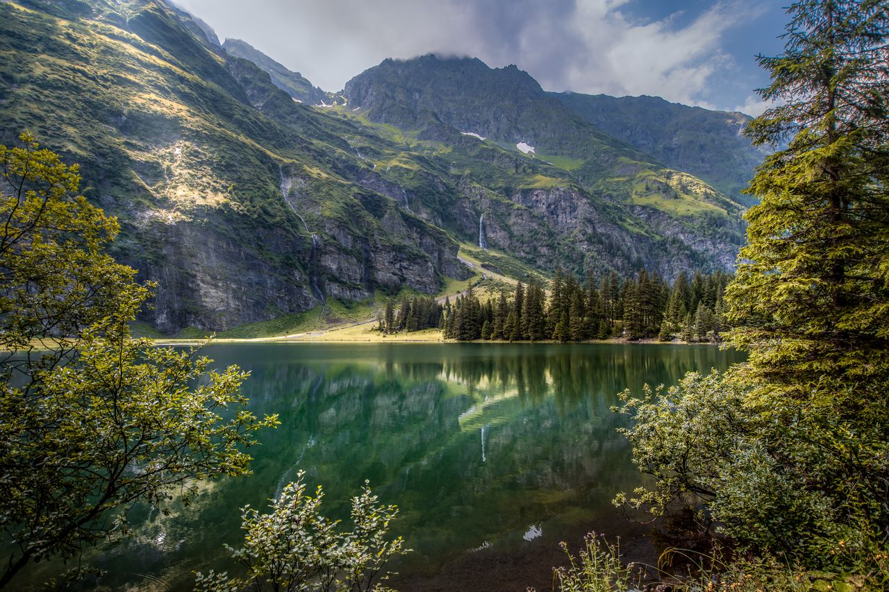 tranquil landscape with a reflective lake surrounded by mountains and