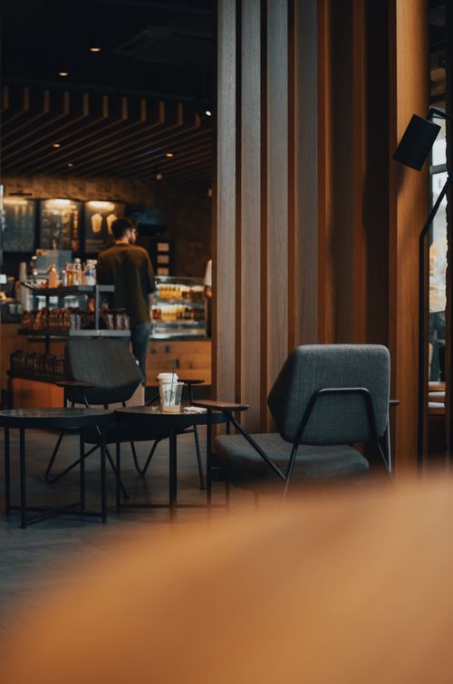 Free Back view of anonymous male customer standing at counter in modern cafe with stylish interior and making order Stock Photo