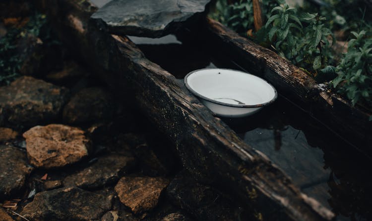 Enamel Bowl On Wooden Aqueduct In Garden