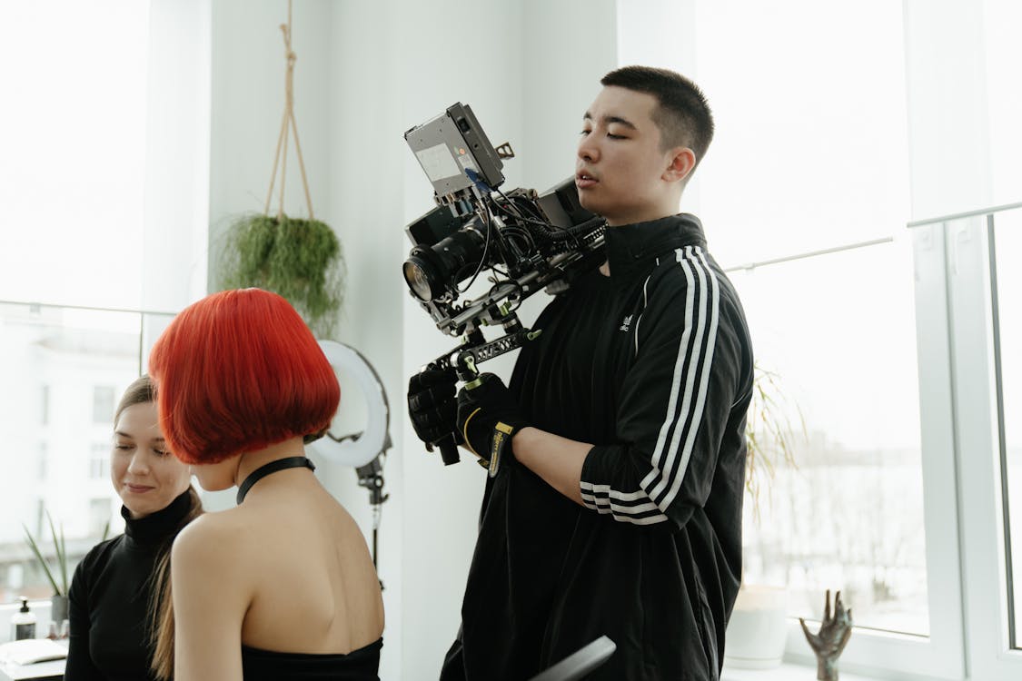 Man in Black and White Stripe Polo Shirt Holding Black Dslr Camera