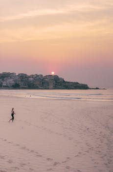 A peaceful sunrise over Bondi Beach in Australia with soft pastel skies and the ocean horizon.