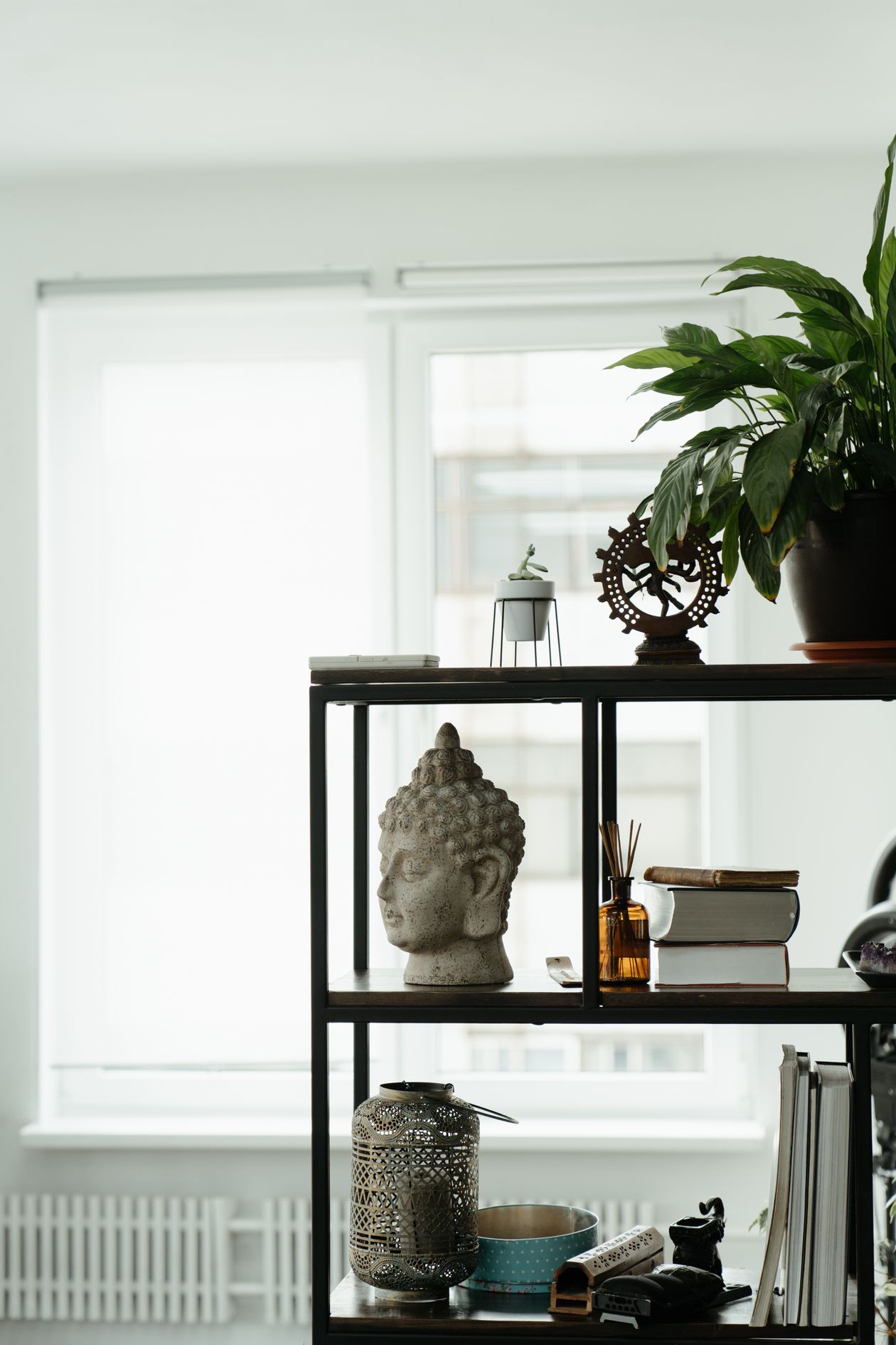 black metal open shelving styled with books and decor in a living room