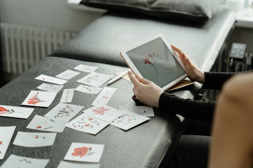 Person Holding White Ipad on White and Black Table