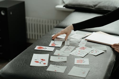 Person Holding Playing Cards on Table