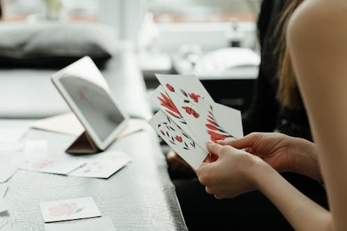 Person Holding White and Red Card