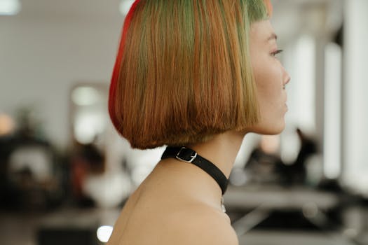 Profile shot of a woman with vibrant, multi-colored bob hairstyle in a modern studio.