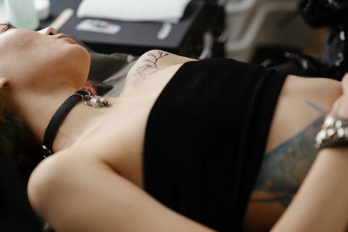 Woman in Black Tank Top Lying on Bed