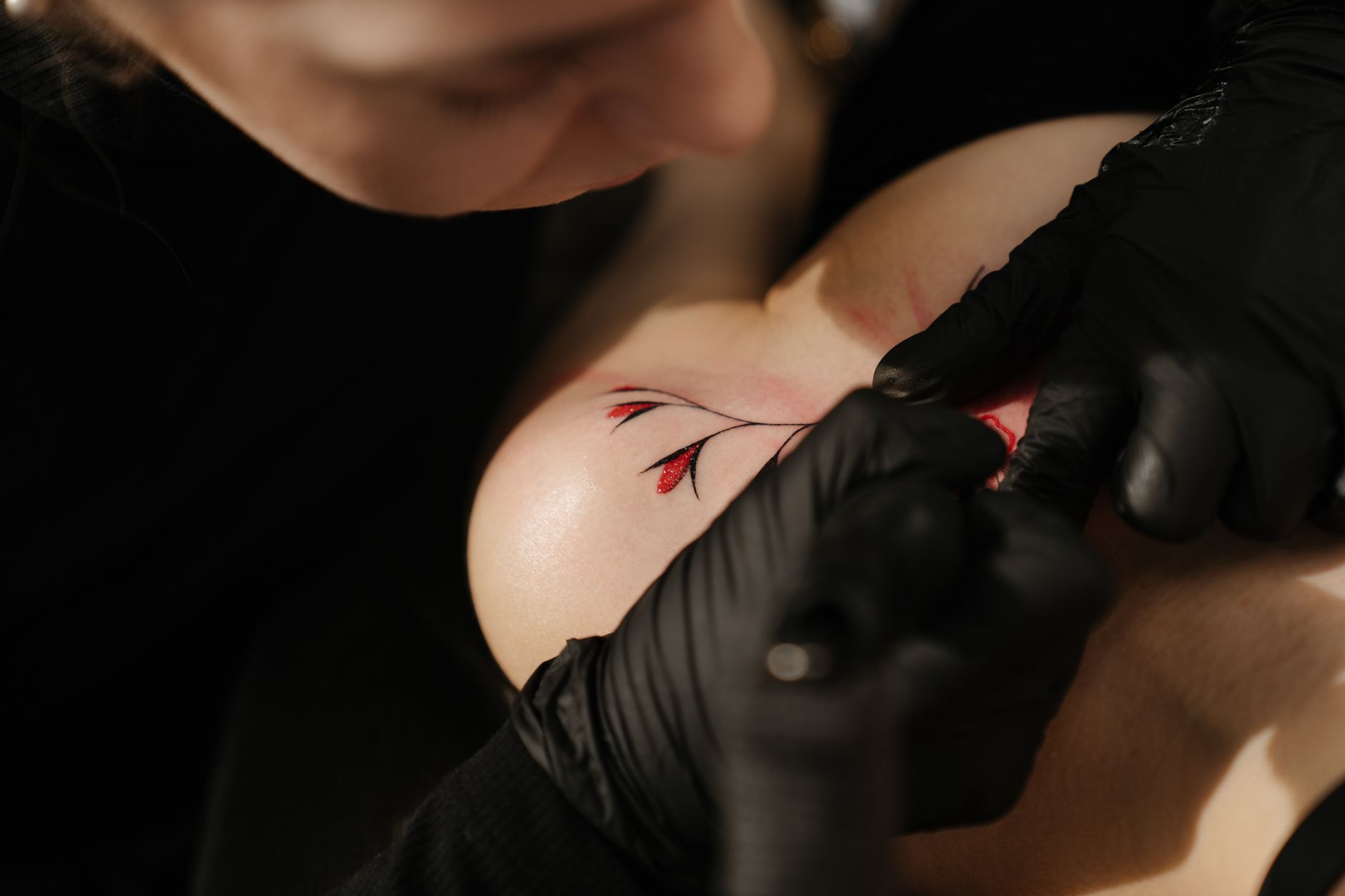Tatouage floral en cours de réalisation, illustrant le choix de la couleur du motif
