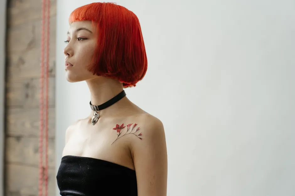 Woman with a small temporary tattoo design on her collarbone, showing a natural, realistic finish