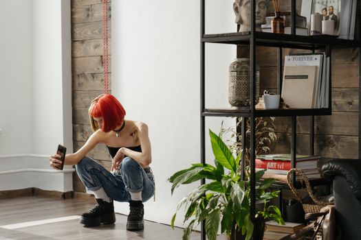 一位红发女子在时尚工作室里自拍，工作室配有植物和架子