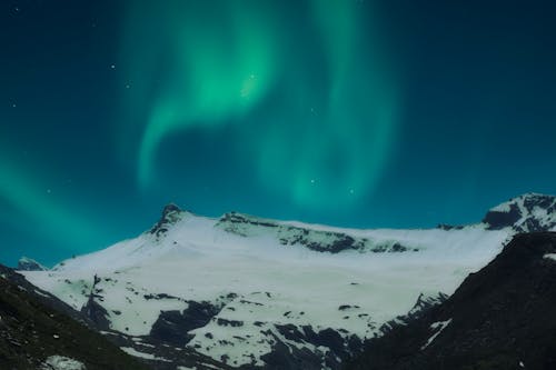 Northern Lights Above Snow Covered Mountain
