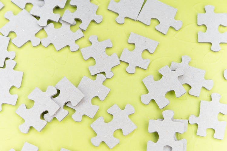 Close-Up Shot Of Jigsaw Puzzle Pieces On A Yellow Surface