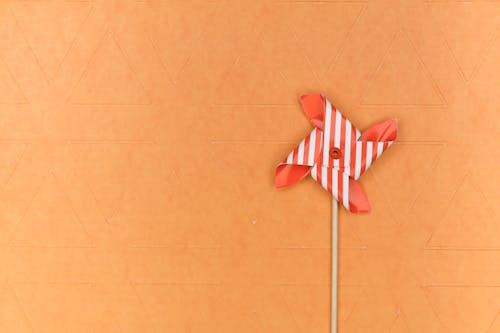 Red and White Pinwheel on Brown Surface