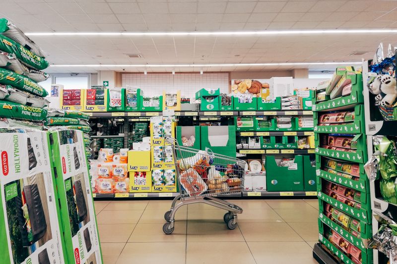 Shopping cart in a vibrant supermarket aisle in Padova, Italy.