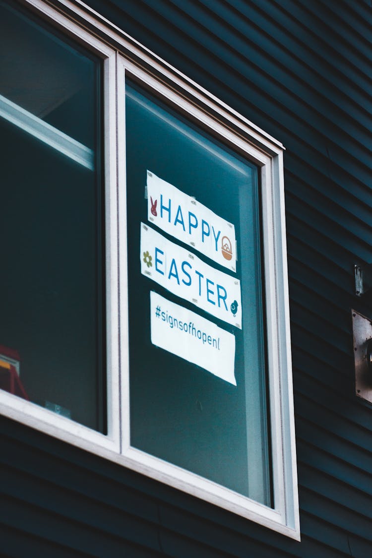 Paper Banner With Easter Greetings On Window