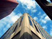 在晴朗的蓝天下，现代办公楼的低视角展现了城市设计