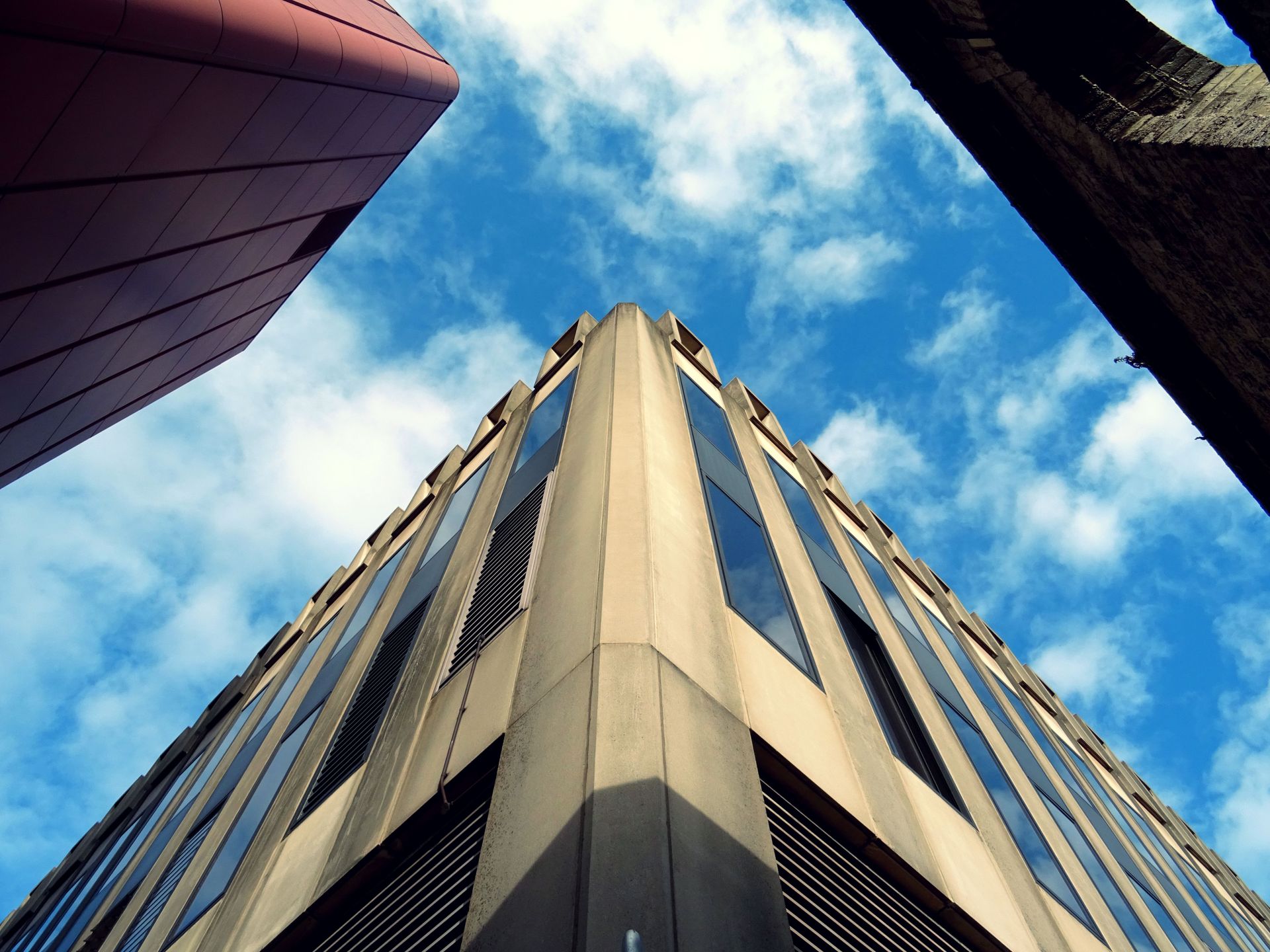 Low angle view of a modern office building against a clear blue sky, showcasing urban design.