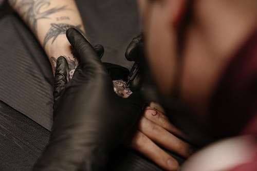 Person Wearing Silver Ring With Black Tattoo