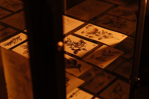 在温暖的灯光下，纹身工作室展示着错综复杂的花卉纹身草图