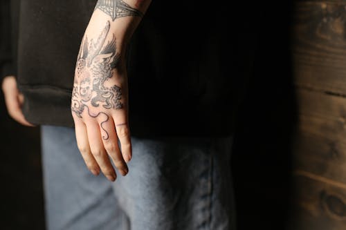 Person With Black Rose Tattoo on Left Hand