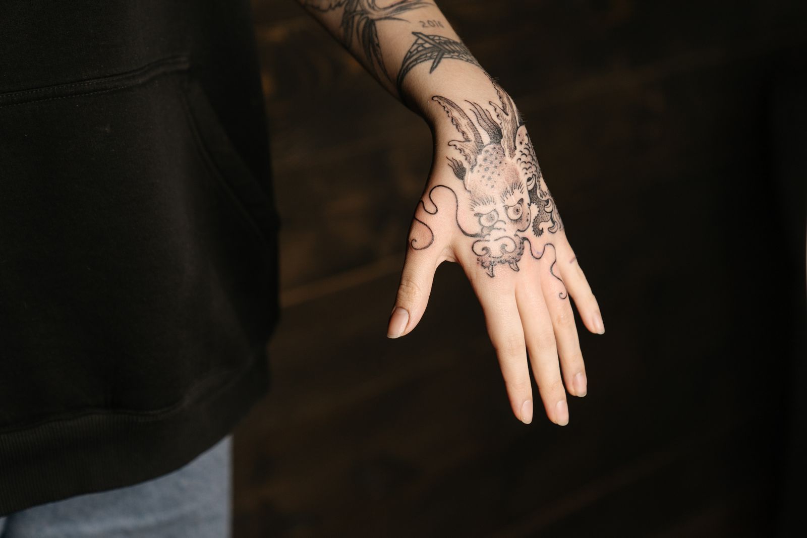 Brazo tatuado con composición oscura