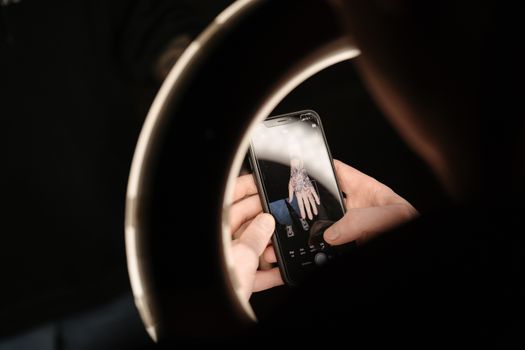 用环形灯照亮纹身，通过智能手机捕捉其详细视图