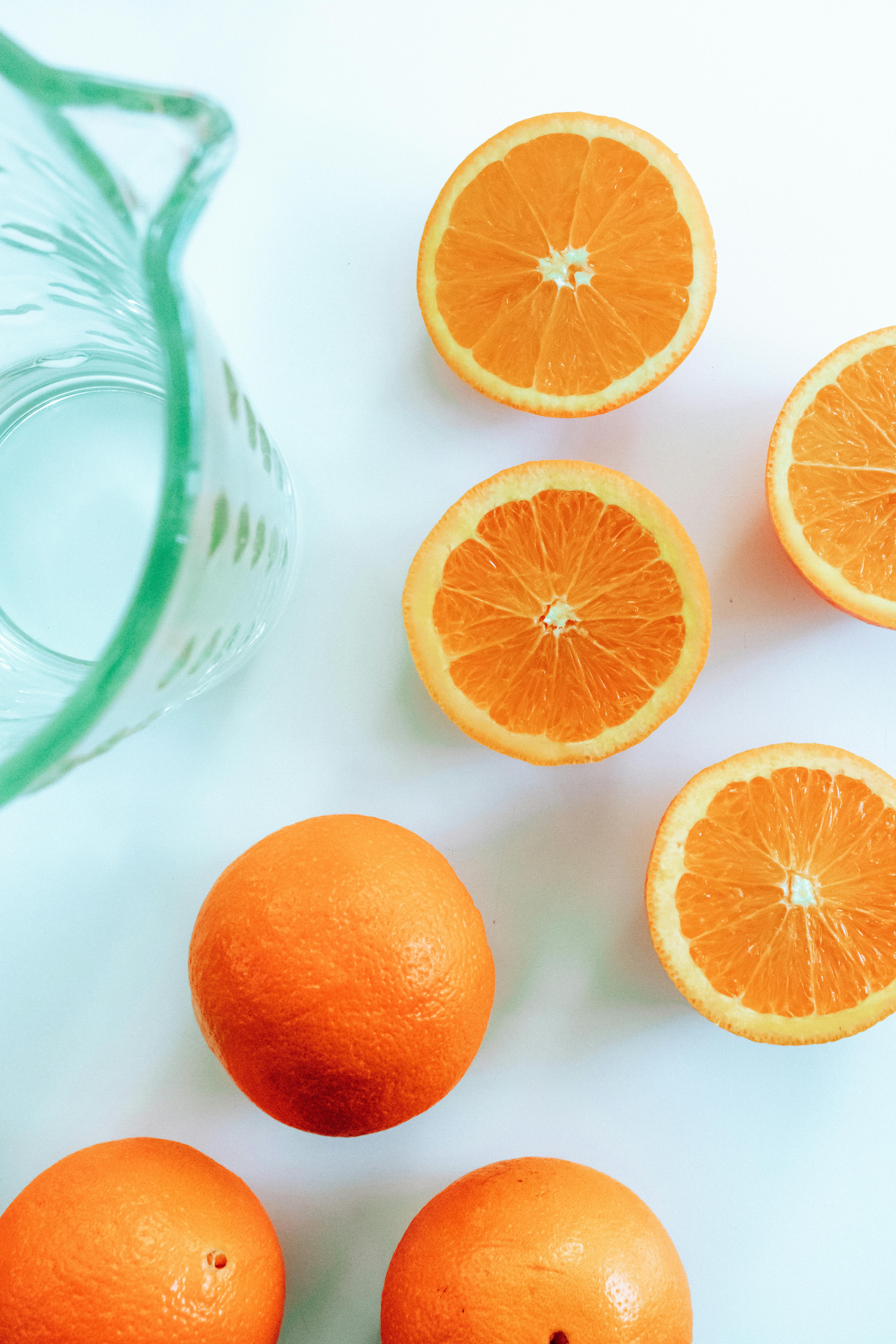 photo of sliced orange near pitcher