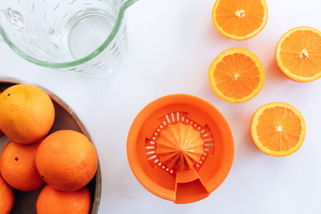 Photo Of Sliced Orange Near Clear Pitcher