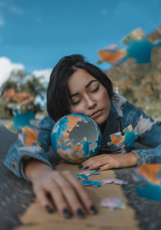 Free Woman in Blue and White Floral Long Sleeve Shirt Holding A Round Shaped Puzzle Stock Photo