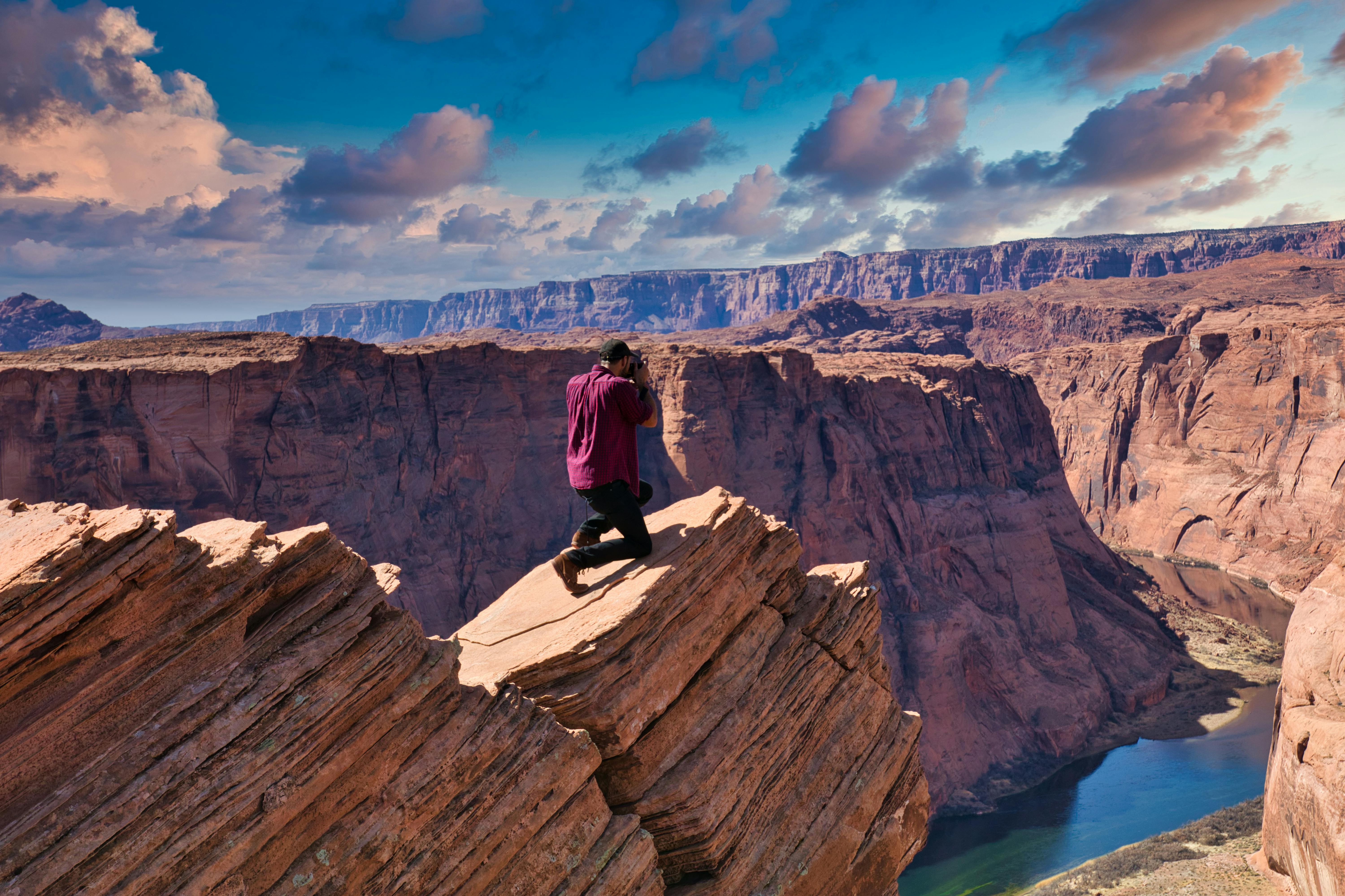 Free A photographer capturing the stunning scenery of Horseshoe Bend, Arizona, under a vivid sky. Stock Photo