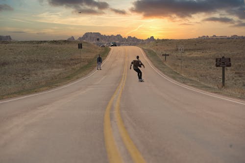 Free Man Riding Skateboard on the Road Stock Photo