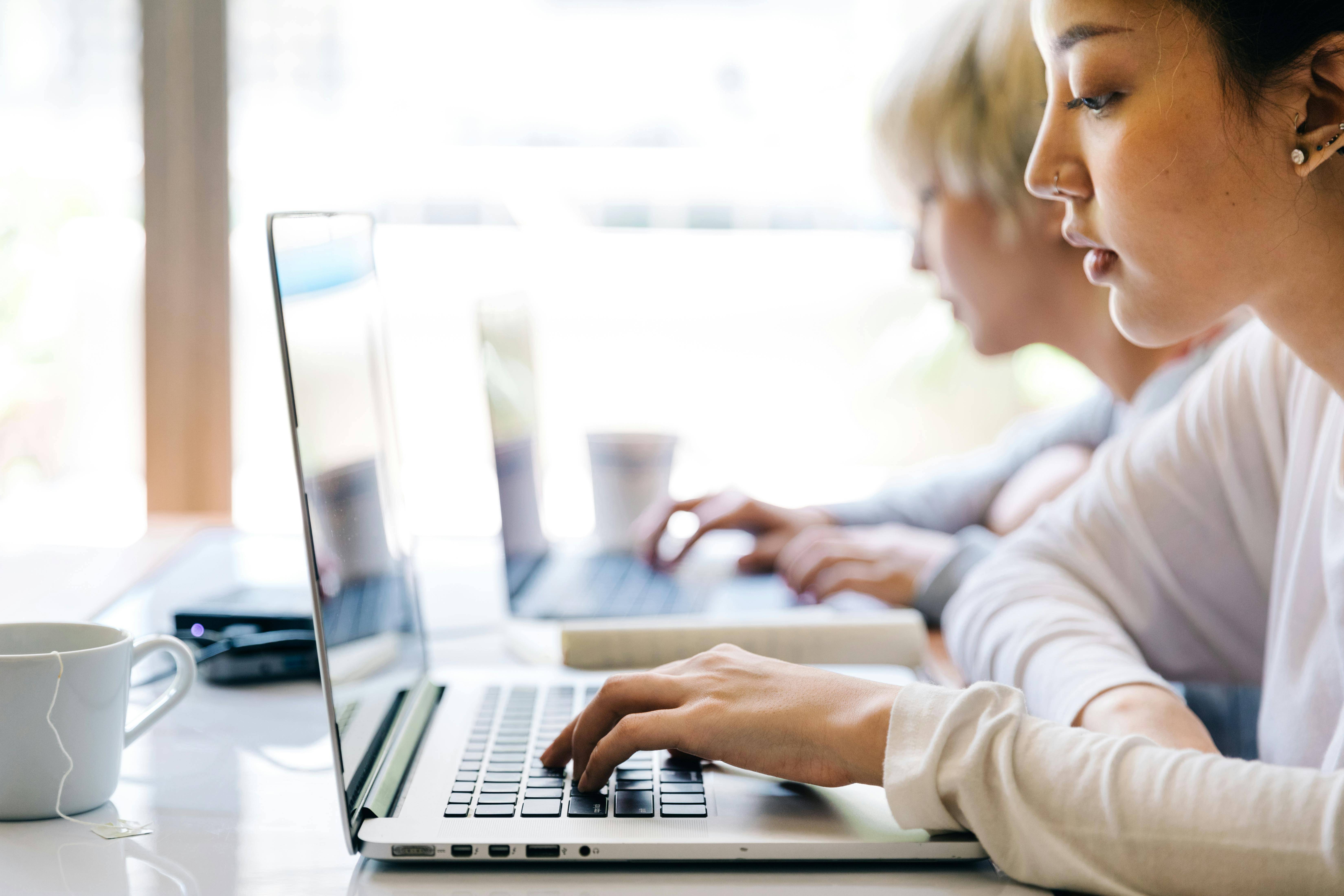 young women working on laptops in creative workspace