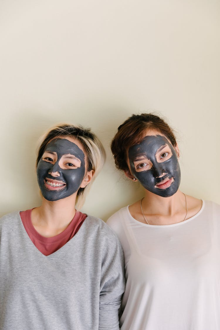 Multiethnic Women With Black Facial Mask On Beige Background