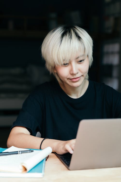 Free Young ethnic woman using laptop in workspace Stock Photo