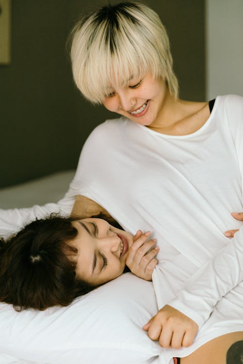 Free Young Women Hugging on Bed Stock Photo