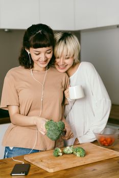 两个女人在厨房里愉快地分享着新鲜蔬菜和咖啡